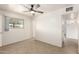 Bedroom showcasing tile flooring, ceiling fan, and an abundance of natural light from the large window at 2802 W Butler Dr, Phoenix, AZ 85051