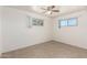 Bright bedroom with a ceiling fan, tile floors, and large windows allowing plenty of natural light at 2802 W Butler Dr, Phoenix, AZ 85051