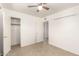 This bedroom features tile flooring, a ceiling fan, and a closet for storage at 2802 W Butler Dr, Phoenix, AZ 85051