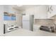 Bright kitchen with white cabinets and appliances, tile countertops, and stainless steel sink at 2802 W Butler Dr, Phoenix, AZ 85051
