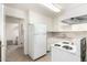 Bright kitchen with white cabinets and appliances, and tile countertops at 2802 W Butler Dr, Phoenix, AZ 85051