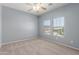 Bedroom with neutral carpet, ceiling fan, and view to neighborhood at 33512 N 24Th Ln, Phoenix, AZ 85085