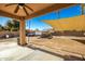 Covered patio with a view of the spacious backyard, complete with gravel, concrete pad, and sunshade at 33602 N Cobble Stone Dr, San Tan Valley, AZ 85143