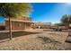 View of the backyard with a covered patio, gravel landscaping, and a trailer with a car on it at 33602 N Cobble Stone Dr, San Tan Valley, AZ 85143
