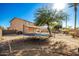 Spacious backyard featuring a trampoline, mature tree, landscaping, sunshade and block fence at 33602 N Cobble Stone Dr, San Tan Valley, AZ 85143