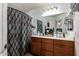 Bathroom with double vanity, full mirror and patterned shower curtain at 33602 N Cobble Stone Dr, San Tan Valley, AZ 85143