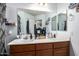 Bright bathroom featuring a double vanity, large mirror, and open shelving at 33602 N Cobble Stone Dr, San Tan Valley, AZ 85143