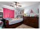 A cozy bedroom with a wood-framed bed, posters on the walls, and a matching wood dresser at 33602 N Cobble Stone Dr, San Tan Valley, AZ 85143
