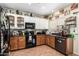 Bright kitchen with upper white cabinets and lower wood cabinets, granite countertops, and stainless steel appliances at 33602 N Cobble Stone Dr, San Tan Valley, AZ 85143