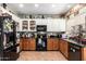 Bright kitchen featuring upper white cabinets and lower wood cabinets, granite countertops, and black appliances at 33602 N Cobble Stone Dr, San Tan Valley, AZ 85143
