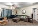 Comfortable living room with neutral carpet, ceiling fan, peacock pillows and a large decorative clock at 33602 N Cobble Stone Dr, San Tan Valley, AZ 85143