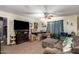 Cozy living room featuring a plush sofa, large TV, ceiling fan and packed moving boxes at 33602 N Cobble Stone Dr, San Tan Valley, AZ 85143
