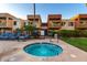 Inviting hot tub with modern tile and surrounding lounge area with palm trees and community buildings at 3500 N Hayden Rd # 710, Scottsdale, AZ 85251