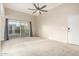 Bright living room featuring neutral carpet, modern ceiling fan, sliding glass door, and access to private outdoor space at 3500 N Hayden Rd # 710, Scottsdale, AZ 85251