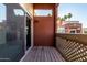 Patio with sliding glass door and wood decking overlooking surrounding buildings and palm trees at 3500 N Hayden Rd # 710, Scottsdale, AZ 85251