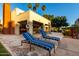 Community patio with lounge chairs and palm trees, with a community building in the background at 3500 N Hayden Rd # 710, Scottsdale, AZ 85251