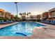 Sparkling community pool with inviting blue water surrounded by lounge chairs, palm trees, and well-kept landscaping at 3500 N Hayden Rd # 710, Scottsdale, AZ 85251