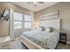 Bright bedroom featuring an ornate headboard, ceiling fan, and light-filled window at 35486 N Morello Dr, Queen Creek, AZ 85140