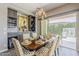 This dining room offers patio access, bar storage, decorative art, a lovely chandelier, and yellow and white chairs at 35486 N Morello Dr, Queen Creek, AZ 85140