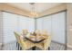 This dining room offers natural lighting with neutral blinds, a lovely chandelier, and yellow and white chairs at 35486 N Morello Dr, Queen Creek, AZ 85140