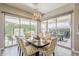 This bright dining room is decorated with a lovely chandelier, yellow and white chairs, and an outdoor patio view at 35486 N Morello Dr, Queen Creek, AZ 85140