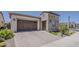 View of the home's exterior highlighting the 2-car garage and brick driveway at 35486 N Morello Dr, Queen Creek, AZ 85140