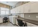 Spacious laundry room with washer, dryer, upper cabinets, and built-in desks at 35486 N Morello Dr, Queen Creek, AZ 85140