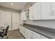 Spacious laundry room with white cabinets and gray countertops, offering ample storage at 35486 N Morello Dr, Queen Creek, AZ 85140