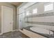 This main bathroom includes a luxury shower, soaking tub, and modern tile accents for a spa-like experience at 35486 N Morello Dr, Queen Creek, AZ 85140