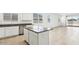 Bright kitchen with white cabinetry, gray countertops, stainless steel appliances and an island at 35941 W San Ildefanso Ave, Maricopa, AZ 85138