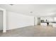 Bright, open-concept living room with tile floors, and a view of the kitchen and stainless steel appliances at 35941 W San Ildefanso Ave, Maricopa, AZ 85138
