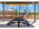 Covered picnic table next to playground equipment offers a comfortable space for relaxation and play at 35941 W San Ildefanso Ave, Maricopa, AZ 85138