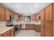 Bright kitchen featuring wood cabinets, stainless steel appliances, and modern flooring at 3719 W Carson Rd, Phoenix, AZ 85041