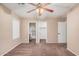 Spacious carpeted bedroom with two entryways, fan, and neutral paint color at 3719 W Carson Rd, Phoenix, AZ 85041