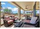Covered backyard patio area with comfortable lounge seating overlooking fire pit and outdoor dining space at 41215 N Lytham Ct, Phoenix, AZ 85086