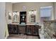 Bathroom features dual sinks with dark wood cabinets, stone surround shower and modern fixtures at 41215 N Lytham Ct, Phoenix, AZ 85086
