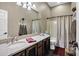 Bathroom featuring a large vanity, a bathtub with shower, and a full-width mirror and wooden cabinets at 41215 N Lytham Ct, Phoenix, AZ 85086