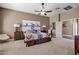 Spacious bedroom featuring carpeted floors, ceiling fan, and a stylish, southwestern-themed bed set at 41215 N Lytham Ct, Phoenix, AZ 85086