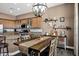 Bright dining area adjacent to kitchen features wood table, matching chairs, chandelier and decorative shelving at 41215 N Lytham Ct, Phoenix, AZ 85086