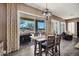 Dining area with a wooden table, modern chandelier, and sliding doors leading to the outdoor patio at 41215 N Lytham Ct, Phoenix, AZ 85086