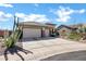 Stylish single-story home with a three-car garage and desert landscaping along the driveway at 41215 N Lytham Ct, Phoenix, AZ 85086