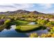 Picturesque view of golf course featuring lush greenery, serene lake, and upscale community backdrop at 41215 N Lytham Ct, Phoenix, AZ 85086