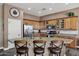 A well-appointed kitchen with granite countertops, stainless steel appliances, an island with bar seating, and wooden cabinets at 41215 N Lytham Ct, Phoenix, AZ 85086