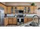 A fully equipped kitchen with stainless steel appliances, granite countertops, and light wood cabinets at 41215 N Lytham Ct, Phoenix, AZ 85086
