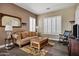 Cozy living room featuring a comfortable couch, wood floors, and plantation shutters at 41215 N Lytham Ct, Phoenix, AZ 85086