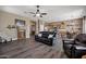 A bright living room features hardwood floors, a ceiling fan, and an open floor plan connecting the kitchen and dining area at 41215 N Lytham Ct, Phoenix, AZ 85086