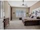 Spacious main bedroom with ceiling fan, shuttered window, and carpet. Features sliding barn door and dresser at 41215 N Lytham Ct, Phoenix, AZ 85086