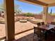 Inviting covered patio with tile flooring, built-in seating, and a cozy fire pit area at 41215 N Lytham Ct, Phoenix, AZ 85086