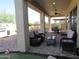 Covered patio area with cushioned chairs, tables, and an outdoor dining set for relaxation at 41215 N Lytham Ct, Phoenix, AZ 85086