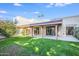Backyard with lush green grass and covered patio with sliding glass doors at 4525 N 66Th St # 95, Scottsdale, AZ 85251